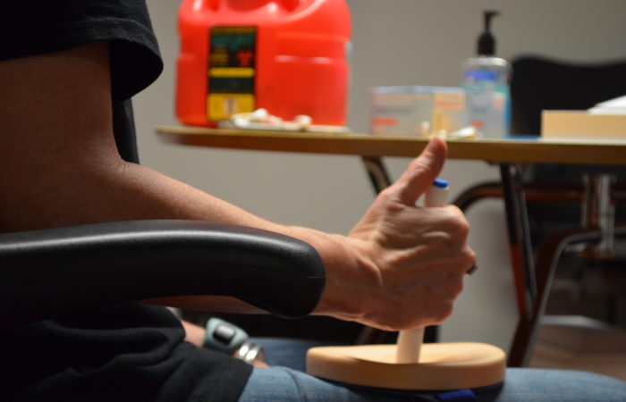 Figure 2: A participant injects with a training device on an injection pad.