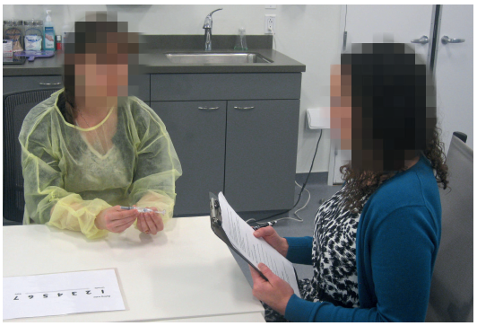 Figure 1: A typical usability test session of a prefilled syringe, with a human factors researcher and test participant sitting in a room.